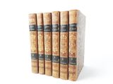 three books are stacked on top of each other on a white surface
