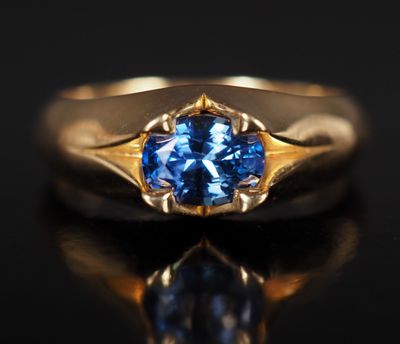 Gros plan sur une bague en or ornée d'un saphir bleu