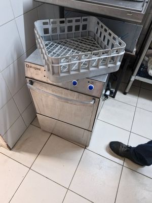 a silver dishwasher sitting on the floor in a kitchen