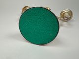 a close up of a green ring on a white surface
