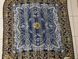 a blue and gold scarf with a monogram on it
