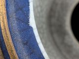 a close up of a blue and gold vase