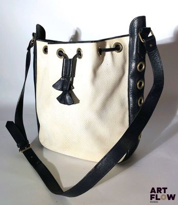 une image représentant un sac noir et blanc orné d'un nœud