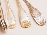 four spoons and a fork on a white surface