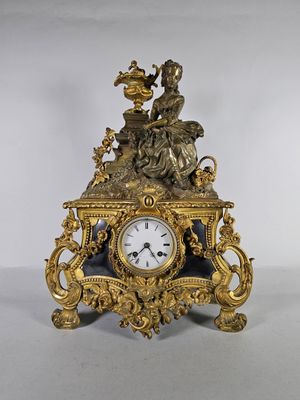 une horloge en or surmontée d'un oiseau