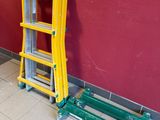 deux échelles posées contre un mur rouge