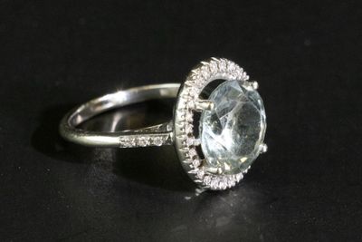 un gros plan d'une bague sertie d'une topaze bleue entourée de diamants blancs