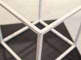 a white metal structure that is on a black table