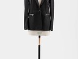 une veste noire posée sur un mannequin, sur fond blanc