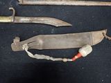 two old knives that are laying on a black surface
