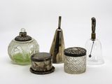trois bocaux en verre et une bouteille en verre posés sur une surface blanche