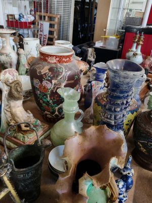 de nombreux vases posés sur la table dans la pièce