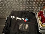 un sac de pizza posé par terre à côté d'une boîte à pizza