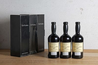 trois bouteilles de vin posées sur une table à côté d'une boîte de vin