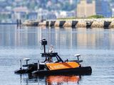un petit bateau orange et noir flottant sur l'eau