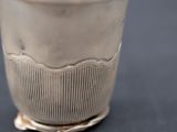 a silver cup that is sitting on a table