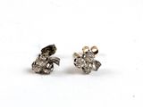 une paire de boucles d'oreilles en diamant sur une surface blanche
