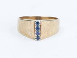 an image of a gold ring with blue sapphires