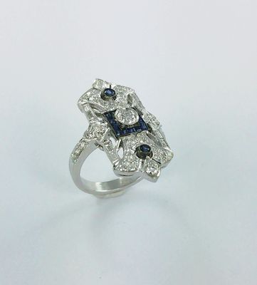 gros plan d'une bague en diamant et saphir sur une surface blanche