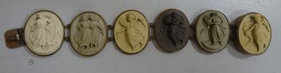 six oval carved cameos of women and men on a white wall