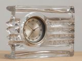 une horloge en verre posée sur une table en bois