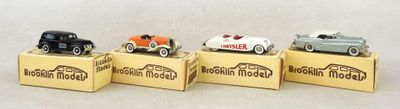trois petites voitures miniatures sont posées sur une boîte en carton