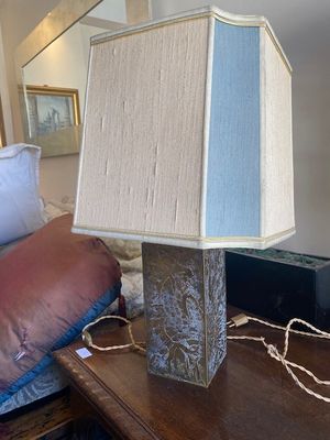 une lampe posée sur une table à côté d'un lit