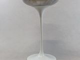 a white pedestal with a silver bowl on top of it