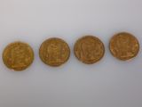 four different types of gold coins on a white surface