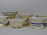 plusieurs vases blancs et dorés posés sur une table blanche