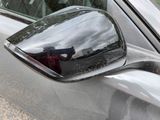 a reflection of a person taking a picture in the side view mirror of a car