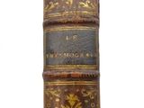 an old leather book with gold and black writing on it