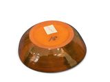 a brown bowl with an orange lid on a white surface