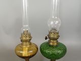 pair of green and gold glass oil lamps on a white background
