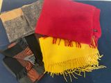 three different colored scarves are on a blue surface