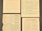 four pages of old paper on top of a black table