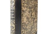 an old book with a gold and black cover on a white background