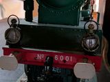 a small green train on display in a museum