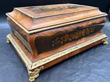 une boîte ancienne en bois ornée d'un motif floral sur le couvercle
