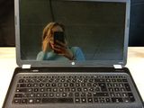un ordinateur portable posé sur une table, avec une personne en train de le prendre en photo