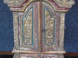 un petit meuble en bois surmonté d'une porte