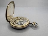 a silver pocket watch that is open on a table
