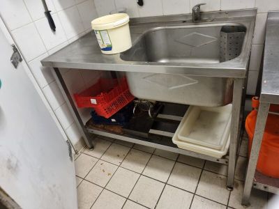 a sink in a small kitchen with a bucket on the counter