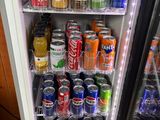a refrigerator full of drinks and sodas in a room