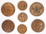 six pièces de bronze présentant différents motifs sur un fond blanc