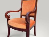 a wooden chair with an orange upholstered seat and arms