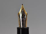 a close up of a fountain pen with a gold nib