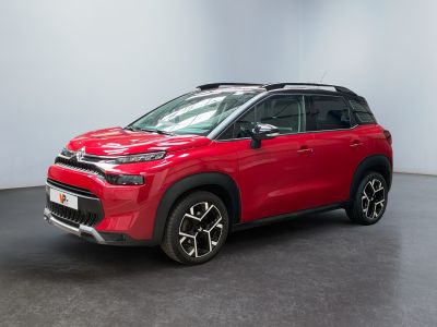 un SUV rouge garé dans une pièce aux murs blancs