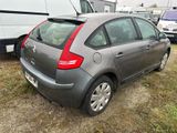 a small grey car parked in a lot next to a trailer