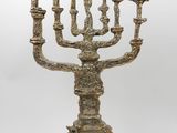 an ornate brass menorah with five candles on a marble base
